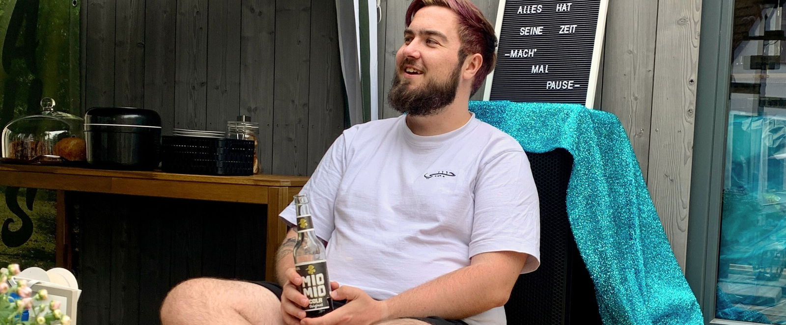 ein Mann in einem Liegestuhl mit einer Limo in der Hand