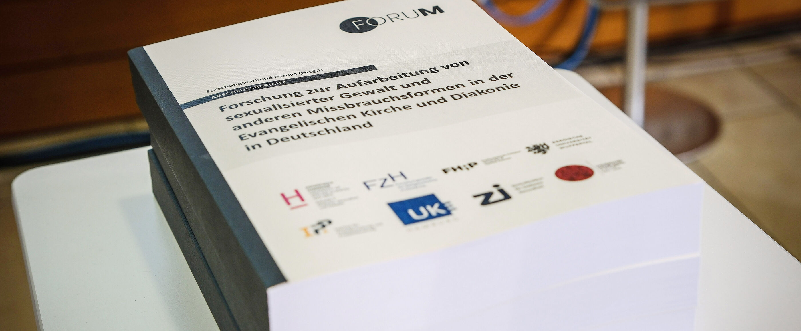 Mehrere Bände einer dicken Studie mit dem Titel „Forschung zur Aufarbeitung von sexualisierter Gewalt und anderen Missbrauchsformen in der Evangelischen Kirche und Diakonie in Deutschland“ liegen übereinander.