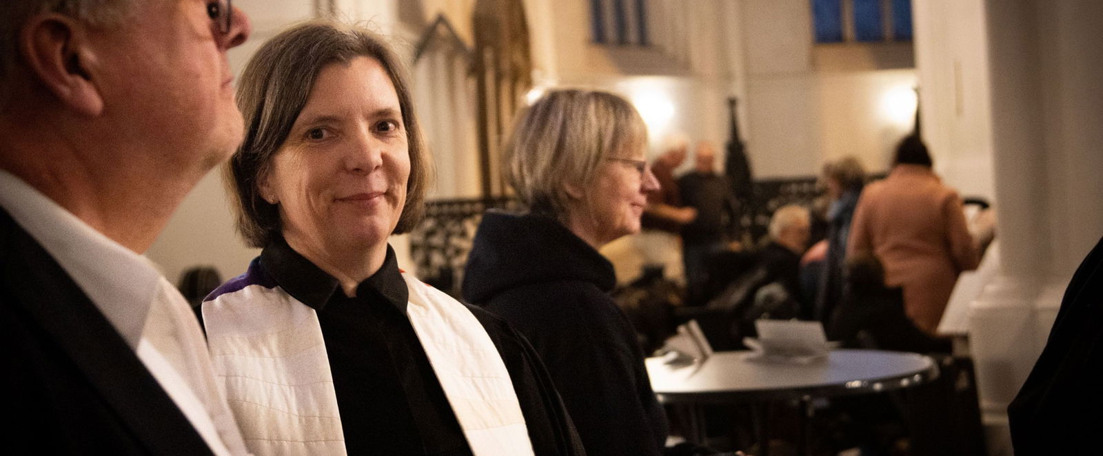 Eine weiblich gelesene Person steht in einem Ornat in der Kirche.