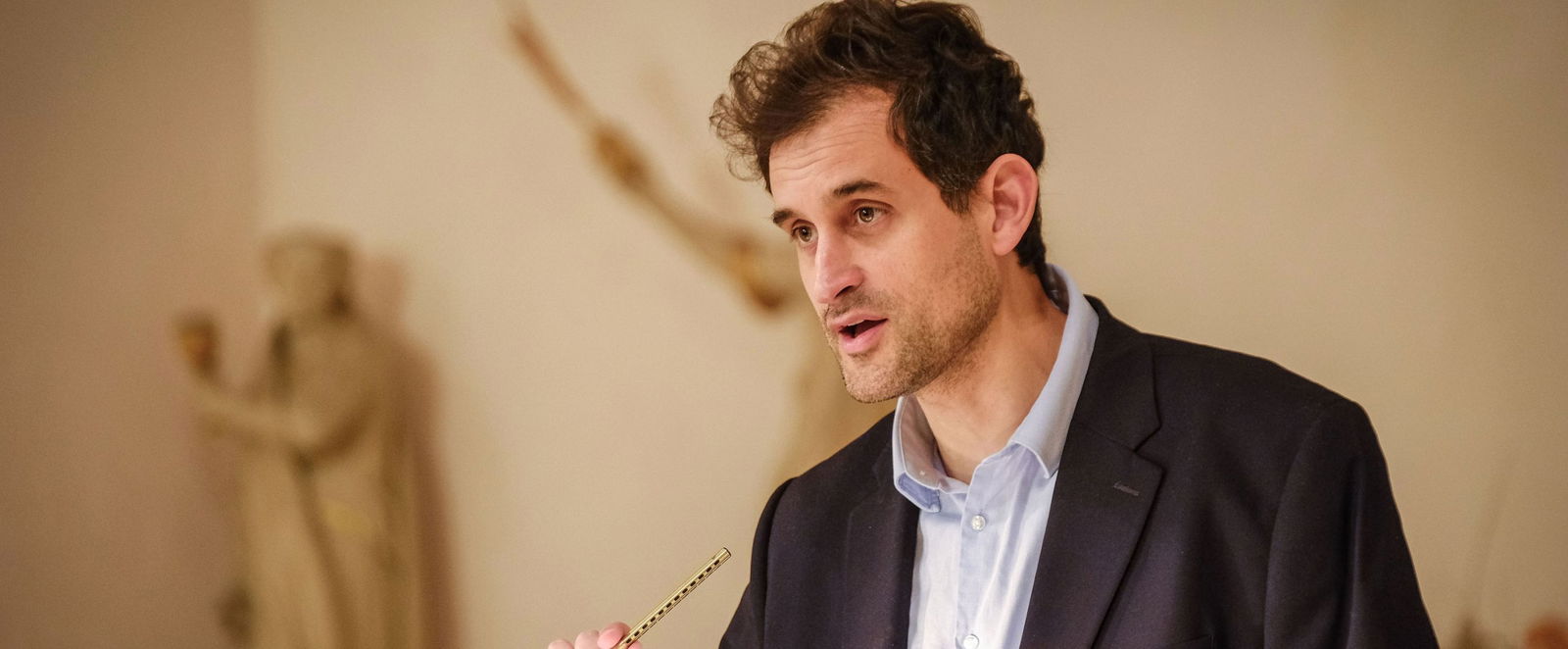 Eine männlich gelesene Person vorm Rednerpult