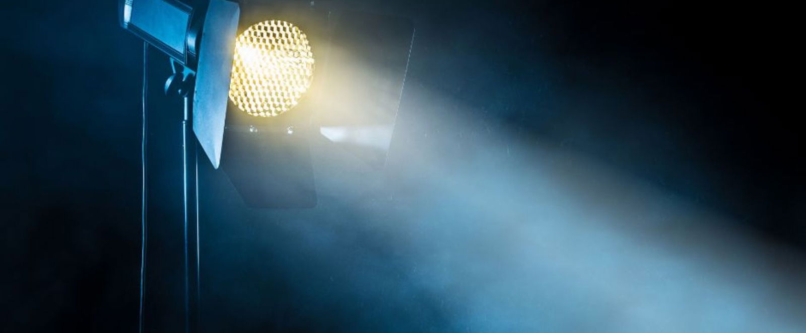 Ein Scheinwerfer steht im Dunkeln und beleuchtet Nebel.