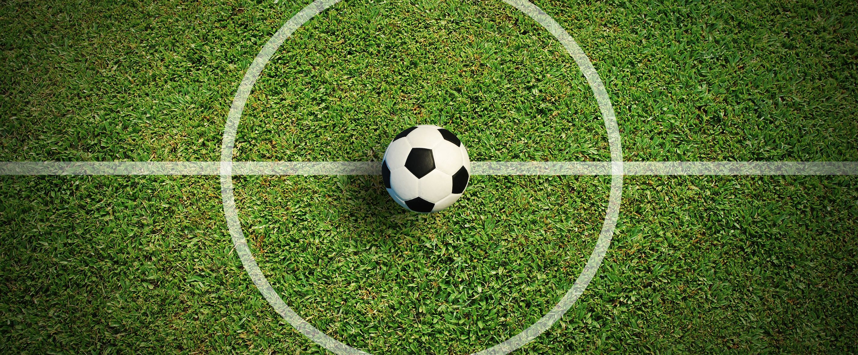 Ein Fußball auf der Mittellinie auf einem Fußballfeld.