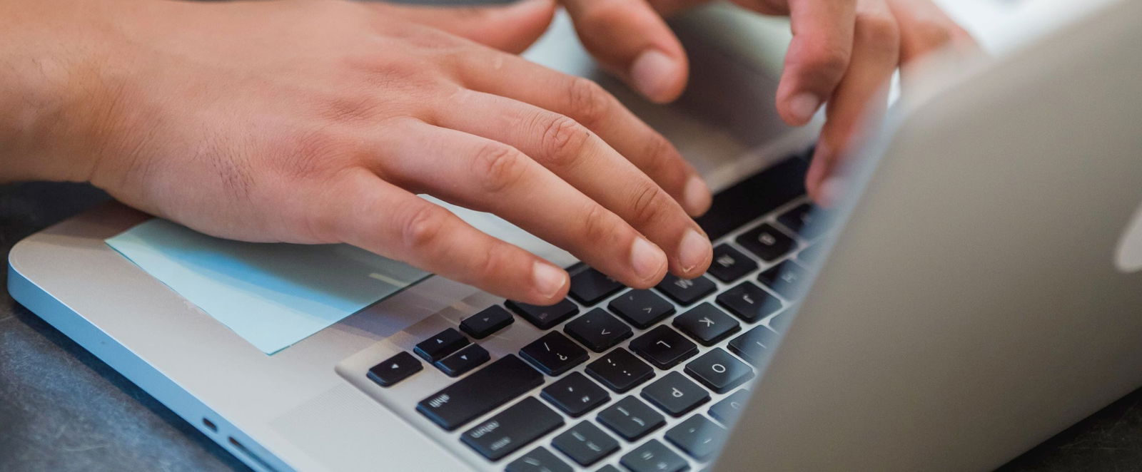 Hände tippen auf einer Computertastatur.