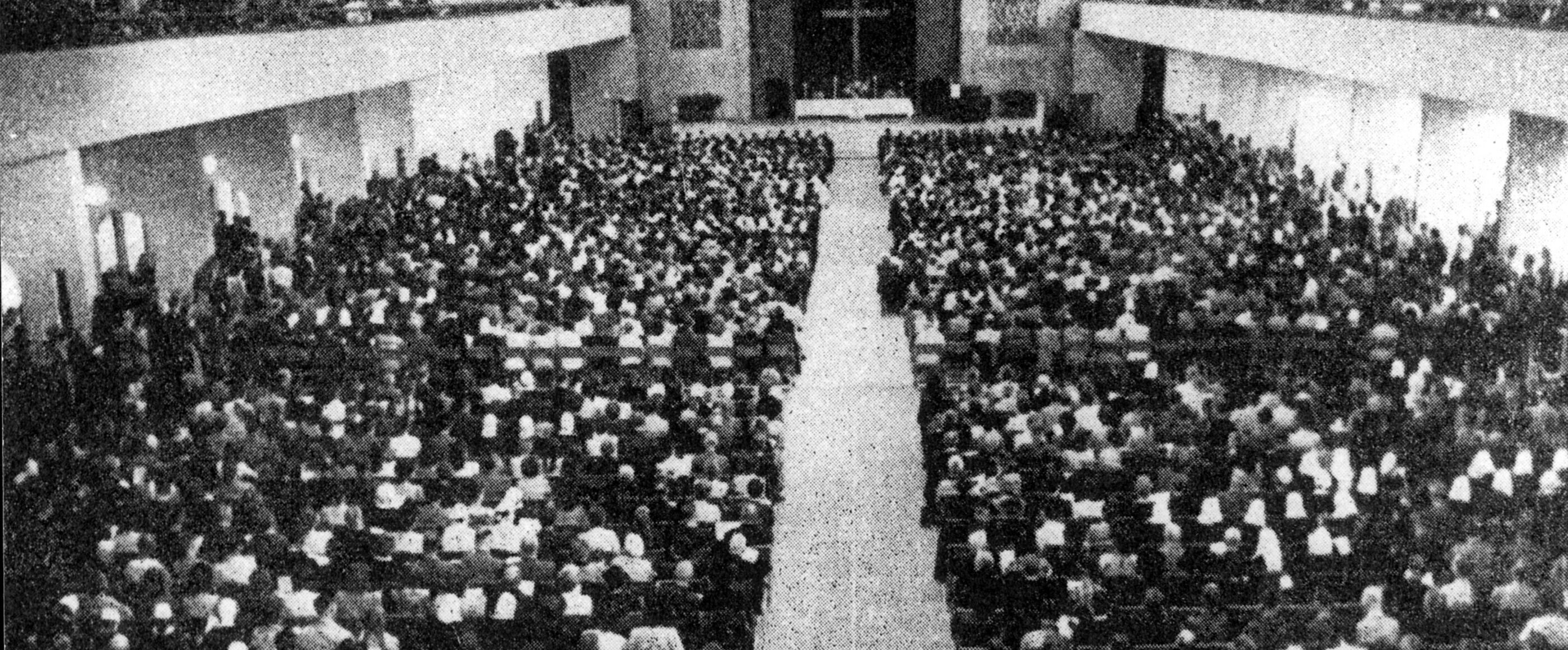 Historisches Schwarzweiß-Foto einer großen Veranstaltung in einer Halle.