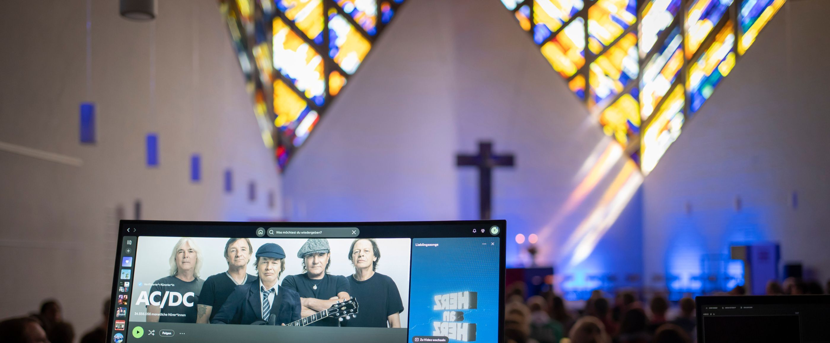 Eine Kirche auf einem Laptop sieht man eine ACDC-Playlist.