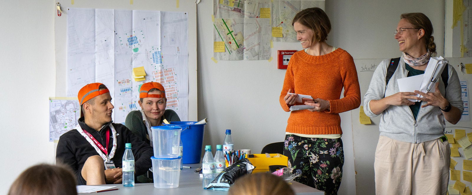 eine Gruppe von Menschen in einem Raum unterhaelt sich