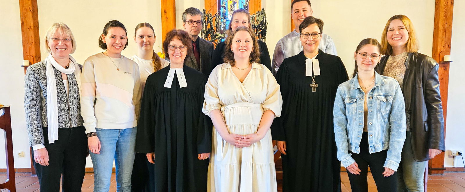 eine Gruppe von MEnschen in einer Kirche schaut in eine Kamera