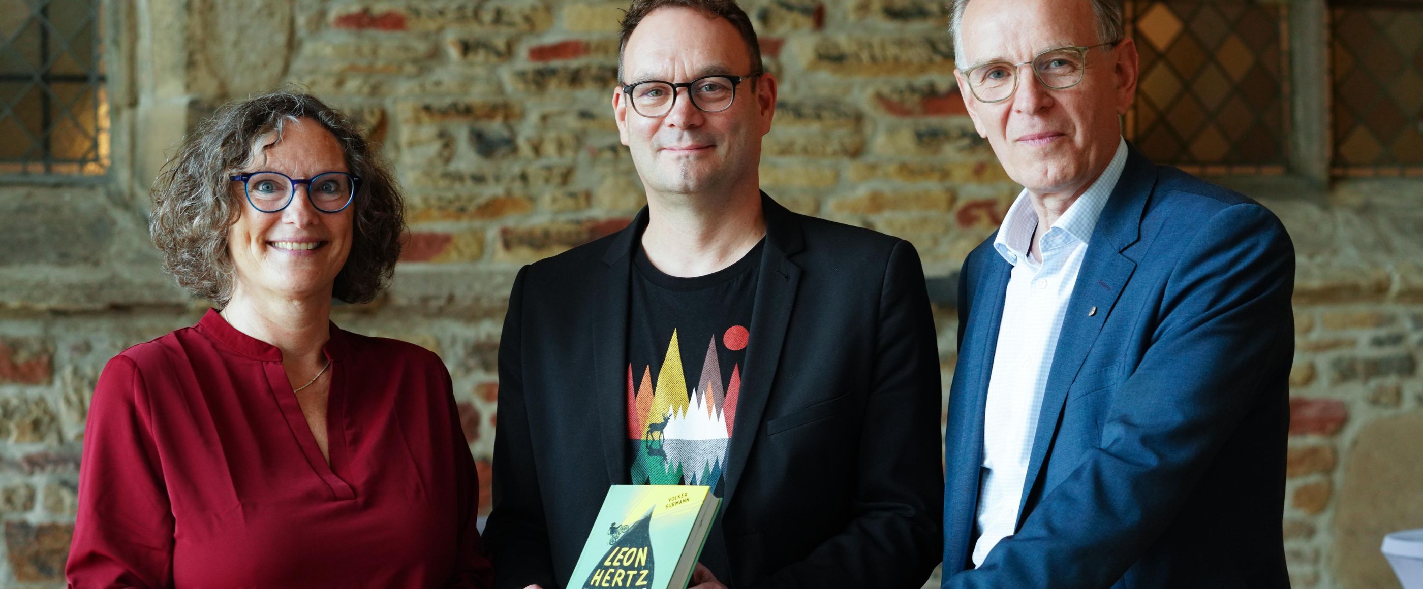 Eine Frau und zwei Männer und ein Buch.