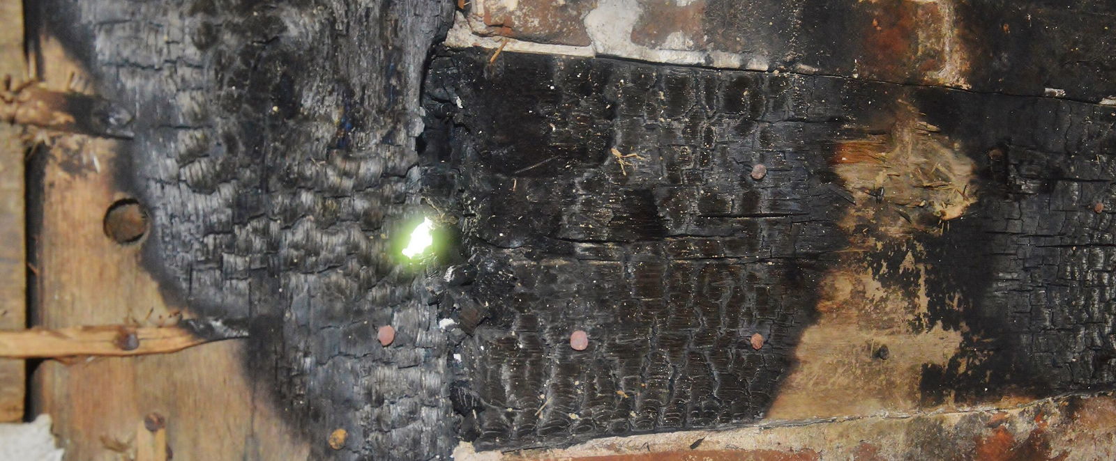 Verkohltes Holz und rußige Backsteine.