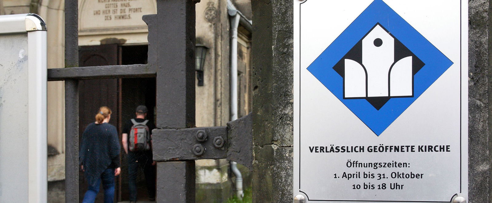 ein Schild mit Kirchensymbol neben einer Eingangstür
