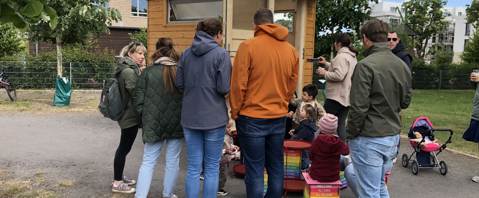 Mehrere Menschen stehen um einen kleinen Bauwagen.