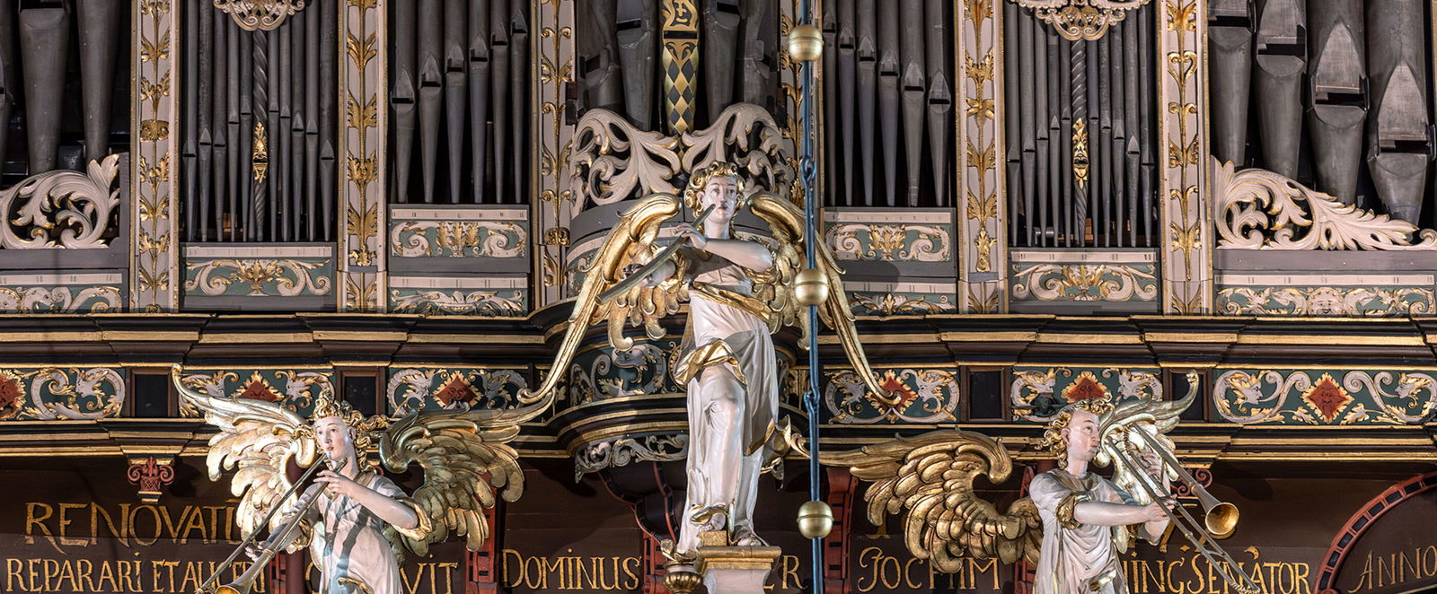 Musizierende Engel schmücken den Prospekt einer Orgel.