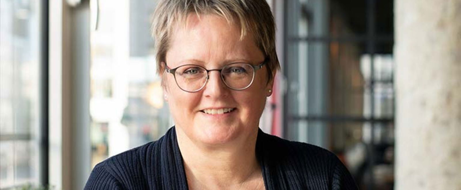 Eine Frau mit kurzen Haaren im Blazer.