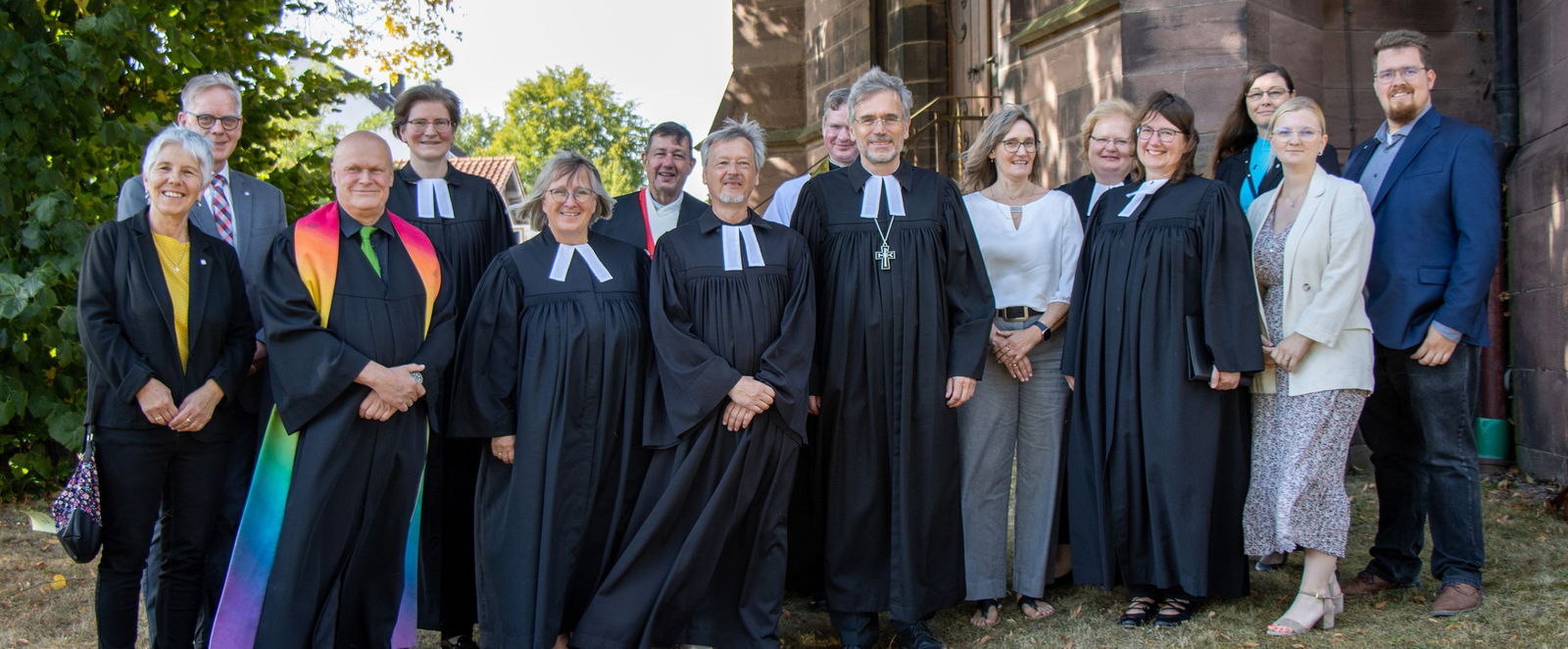 Menschen in Festkleidung vor einer Kirche.