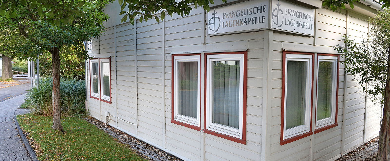 Ein weißes Gebäude mit der Aufschrift Evangelische Lagerkapelle