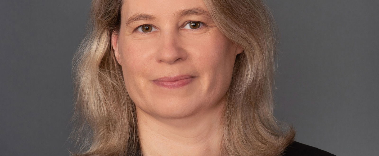 Portraitfoto einer mittelalten als Frau lesbaren Person.