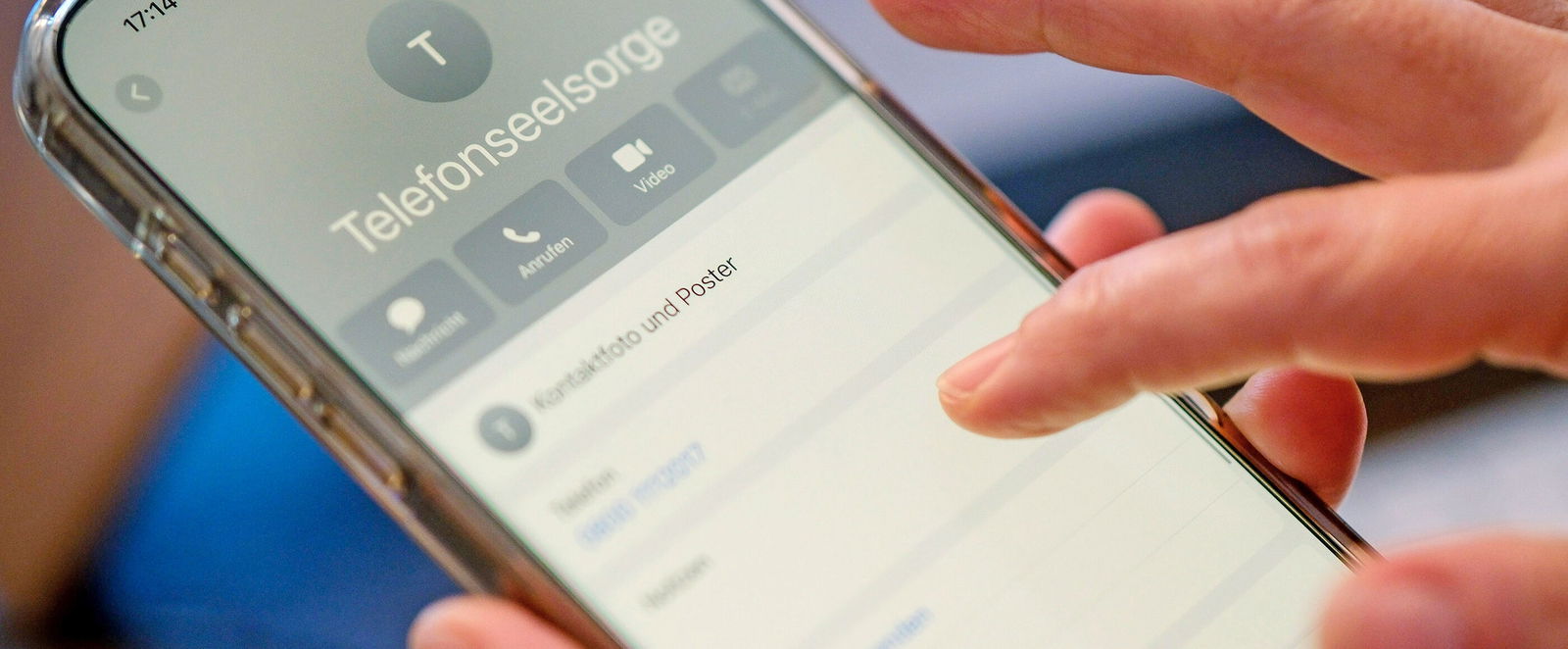 Eine Person wählt auf einem Smartphone die Nummer der Telefonseelsorge.