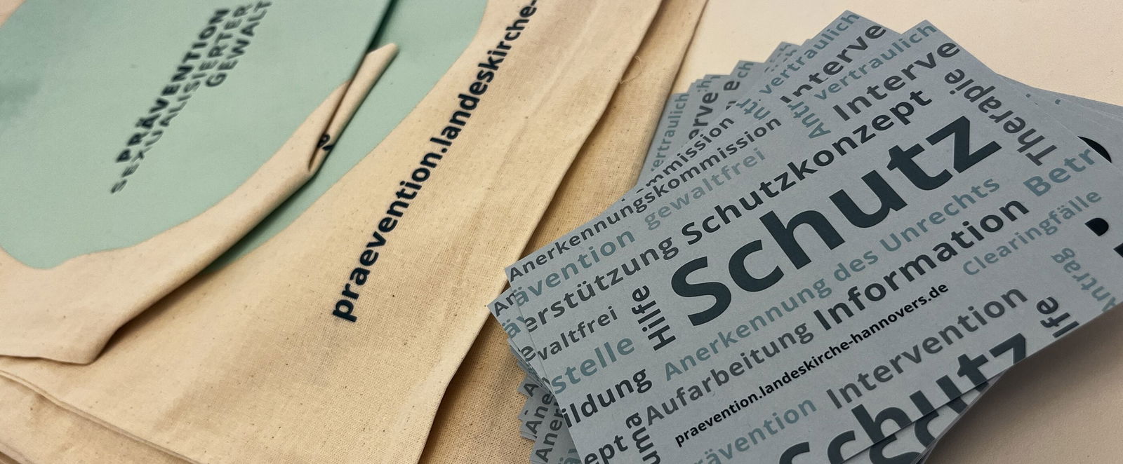 auf einem Tisch liegen Stoffbeutel sowie Postkarten mit Begriffen rund die Prävention sexualisierter Gewalt