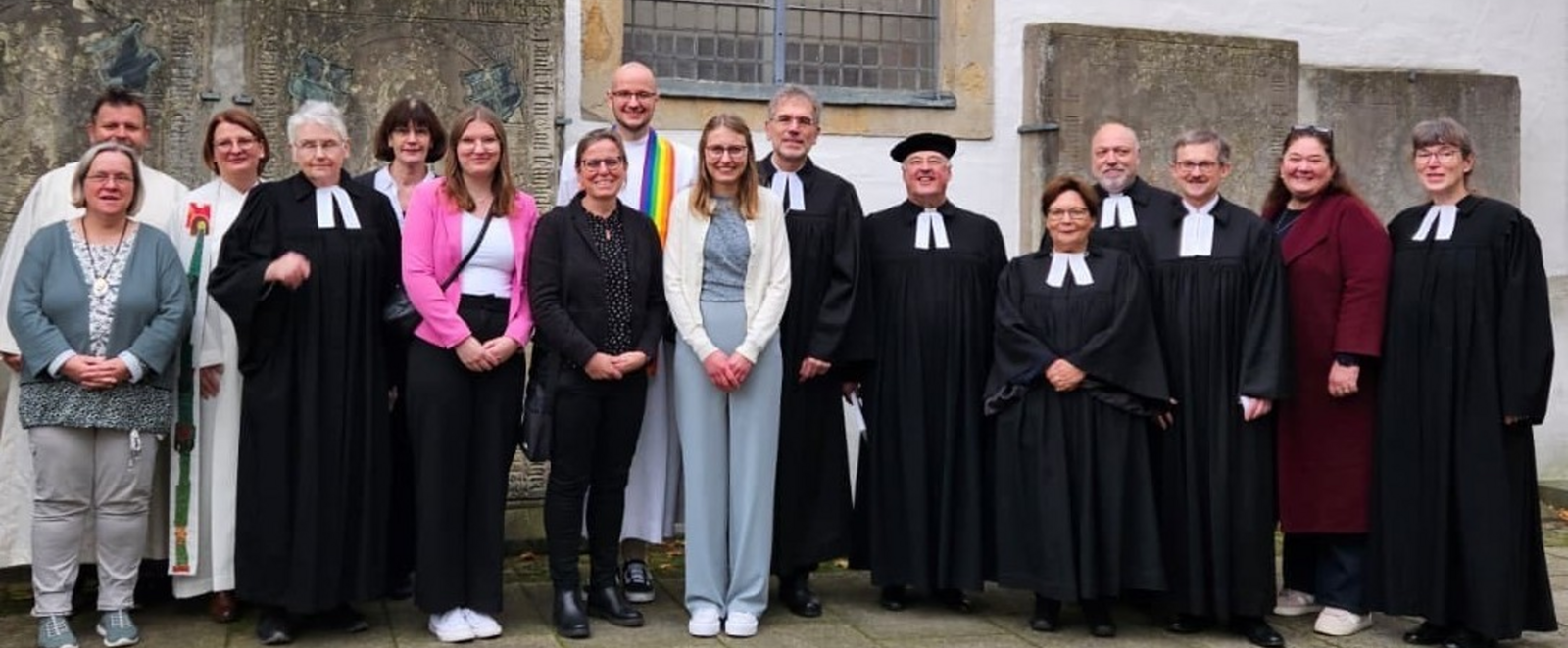 Viele Menschen stehen vor einer Kirche.