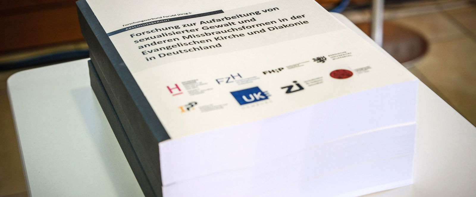Ein Stapel wissenschaftlicher Untersuchungen zum Thema sexualisierte Gewalt in der evangelischen Kirche