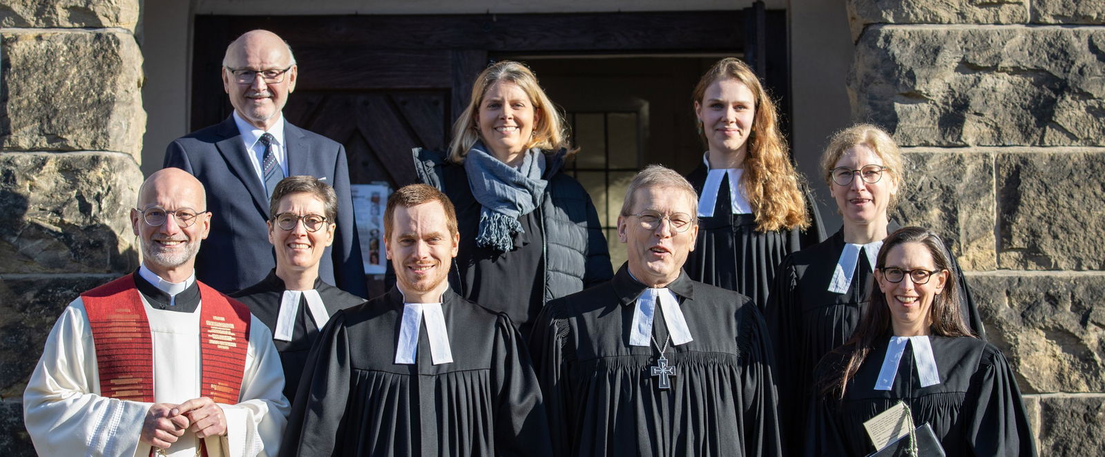 Menschen in Festkleidung vor einer Kirche.