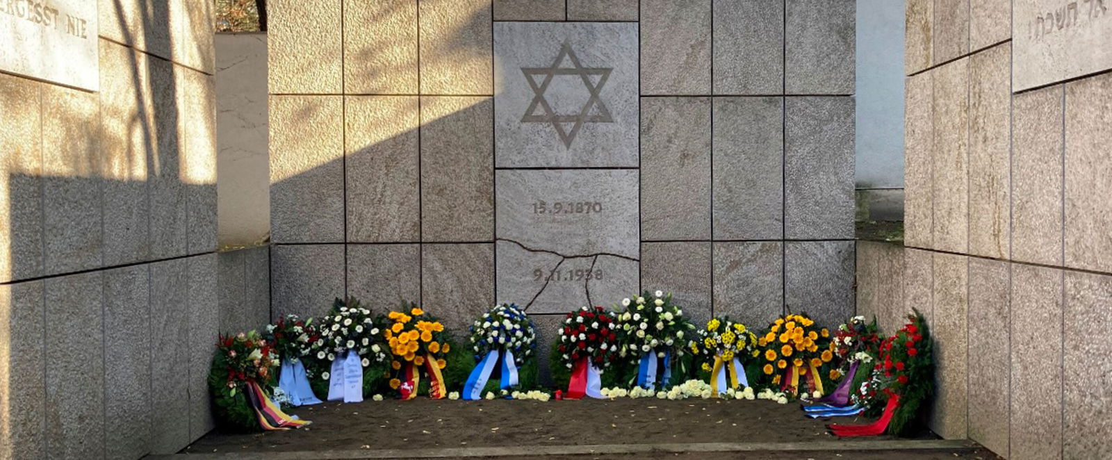 Ein Mahnmal für die Opfer der Judenverfolgung mit Kränzen davor