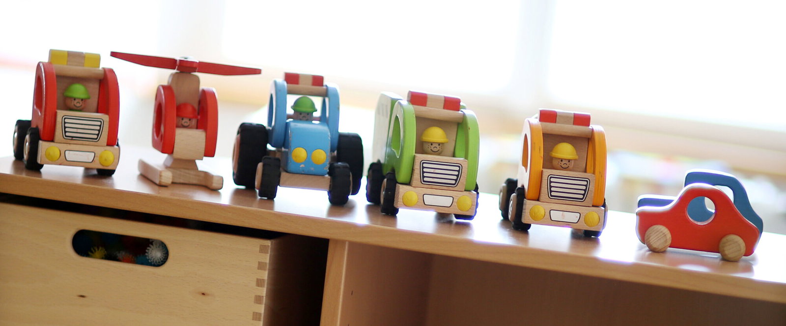 Aufgereihte Holzautos für Kleinkinder