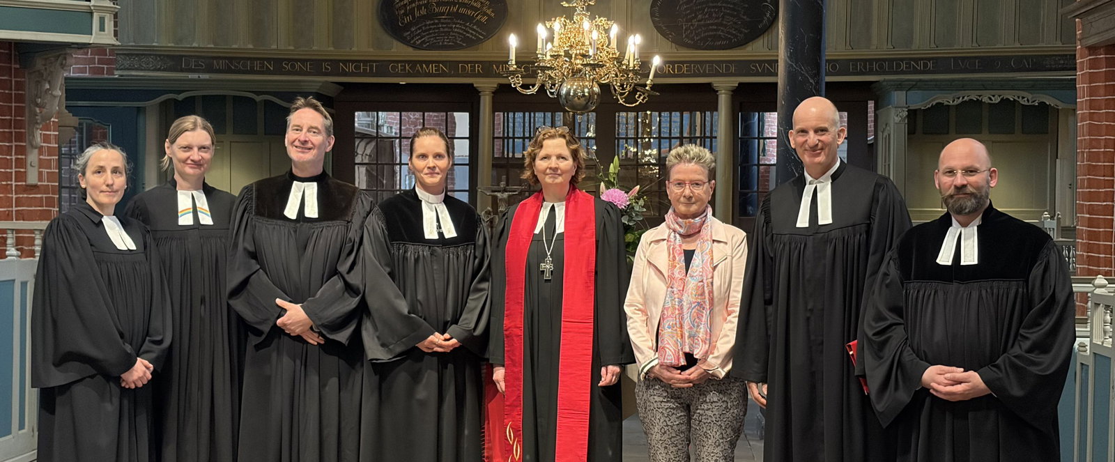 Menschen in einer Kirche, viele mit Talar. 