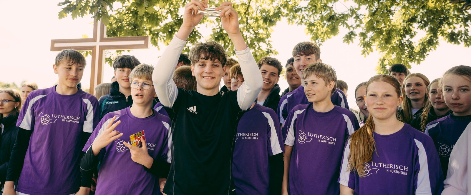 Eine Fußballmannschaft steht hinter einem Banner mit der Aufschrift KonfiCup-Sieger 2026.