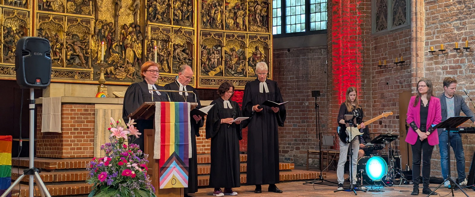 Mehrere Menschen im Altarraum einer Kirche.