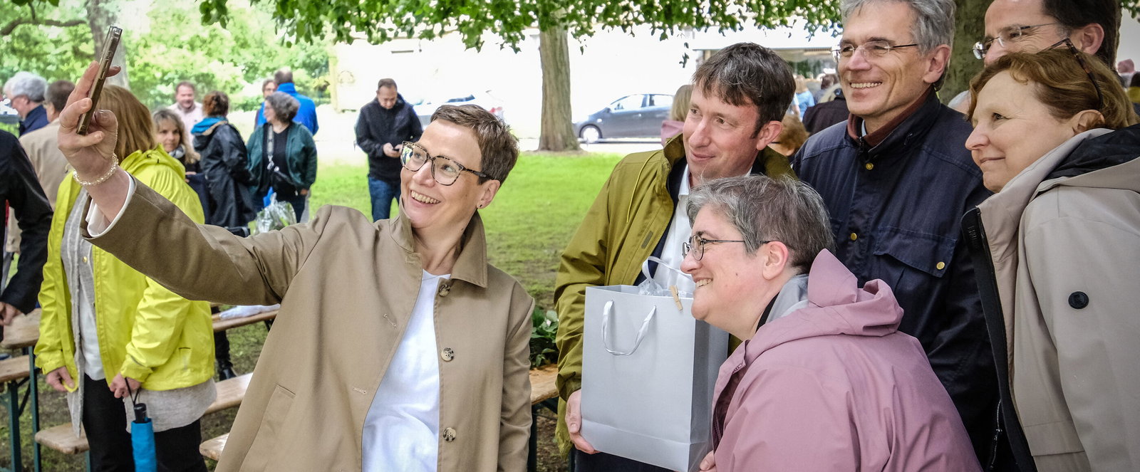 Mehrere als Männer und Frauen lesbare Personen machen ein Selfie.
