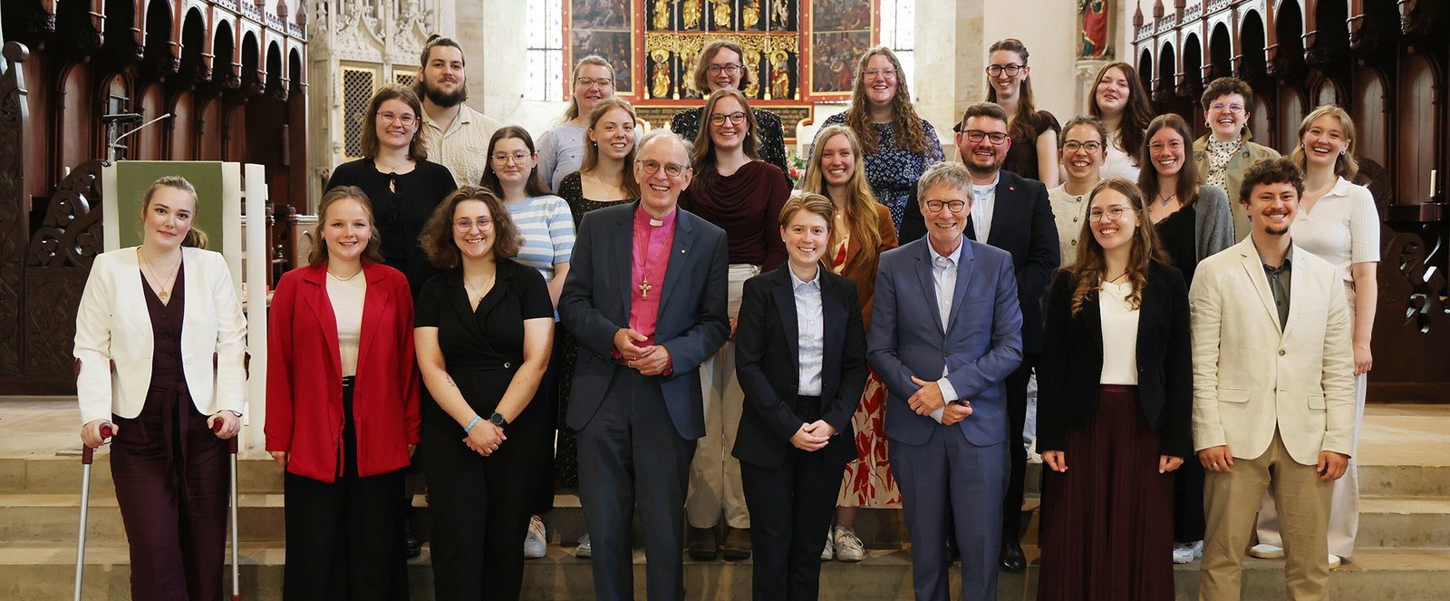 Eine größere Gruppe junger Menschen steht im Altarraum einer Kirche.