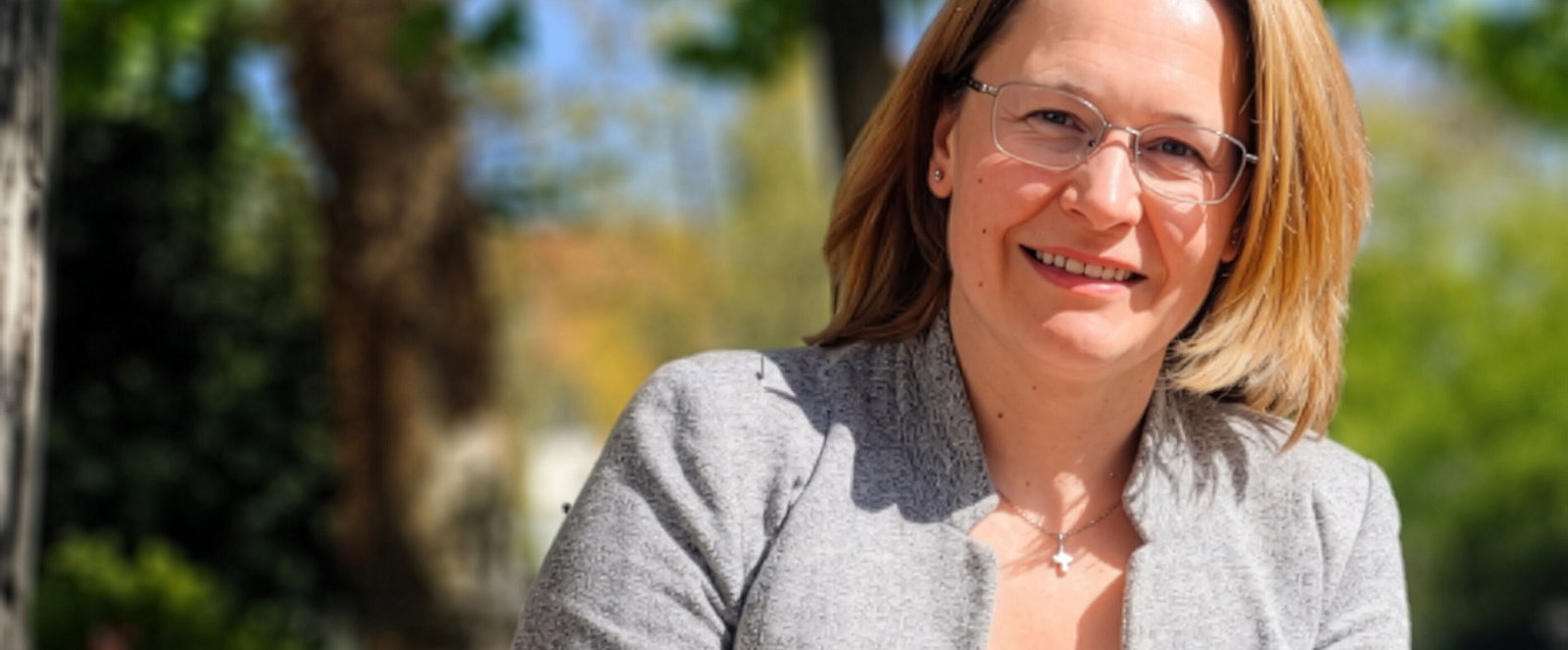 Eine als Frau lesbare Person im Grünen