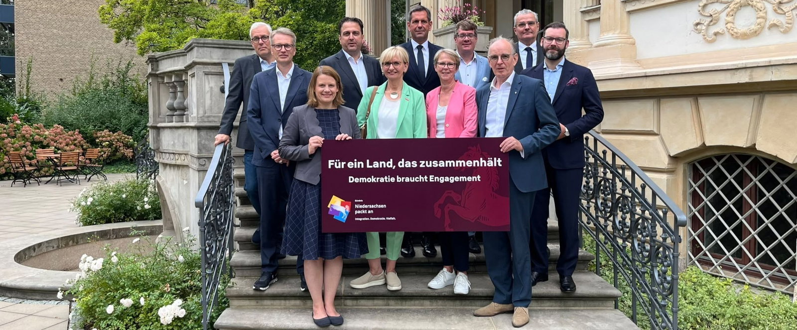 Menschen halten ein Banner.
