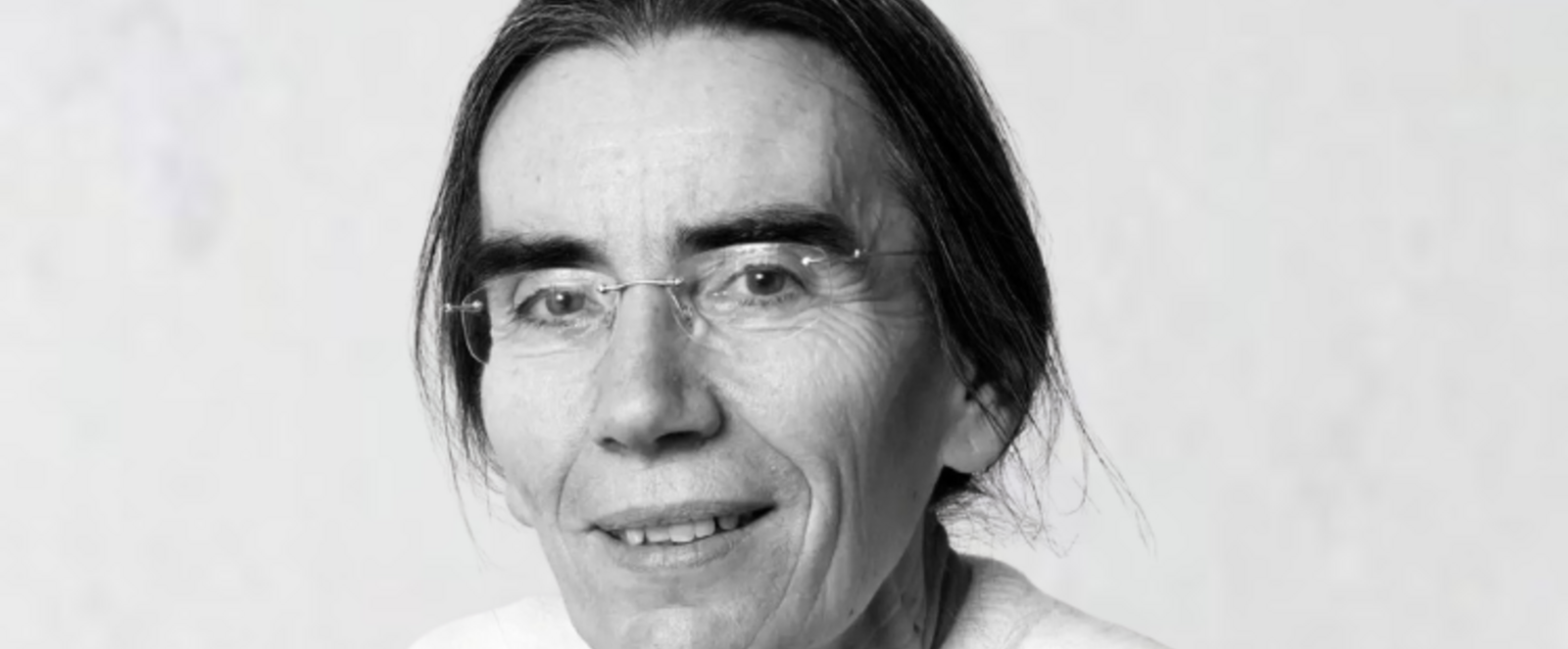 Eine weiblich gelesene Person mit langen zurückgebundenen Haaren und fassungsloser Brille.