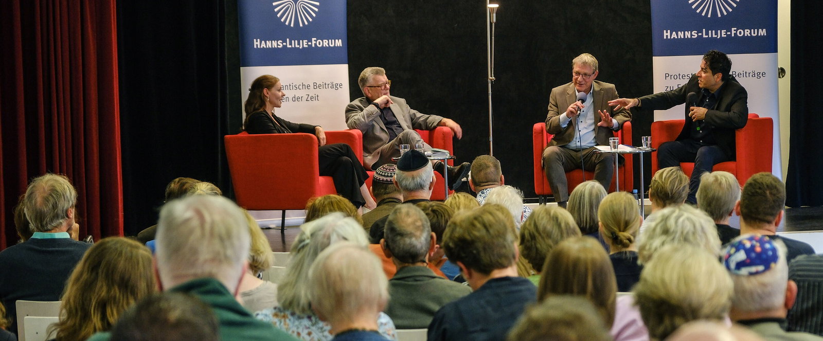 Eine Podiumsdiskussion vor großem Publikum