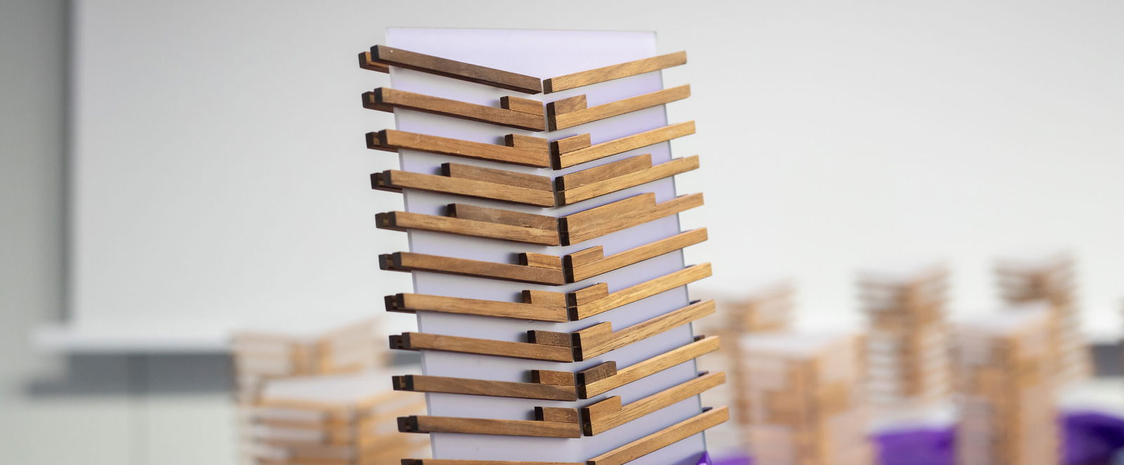 Übereinander liegende, stilisierte Holzseiten bilden den Pokal für die Sieger*innen der Gemeindebriefpreises.