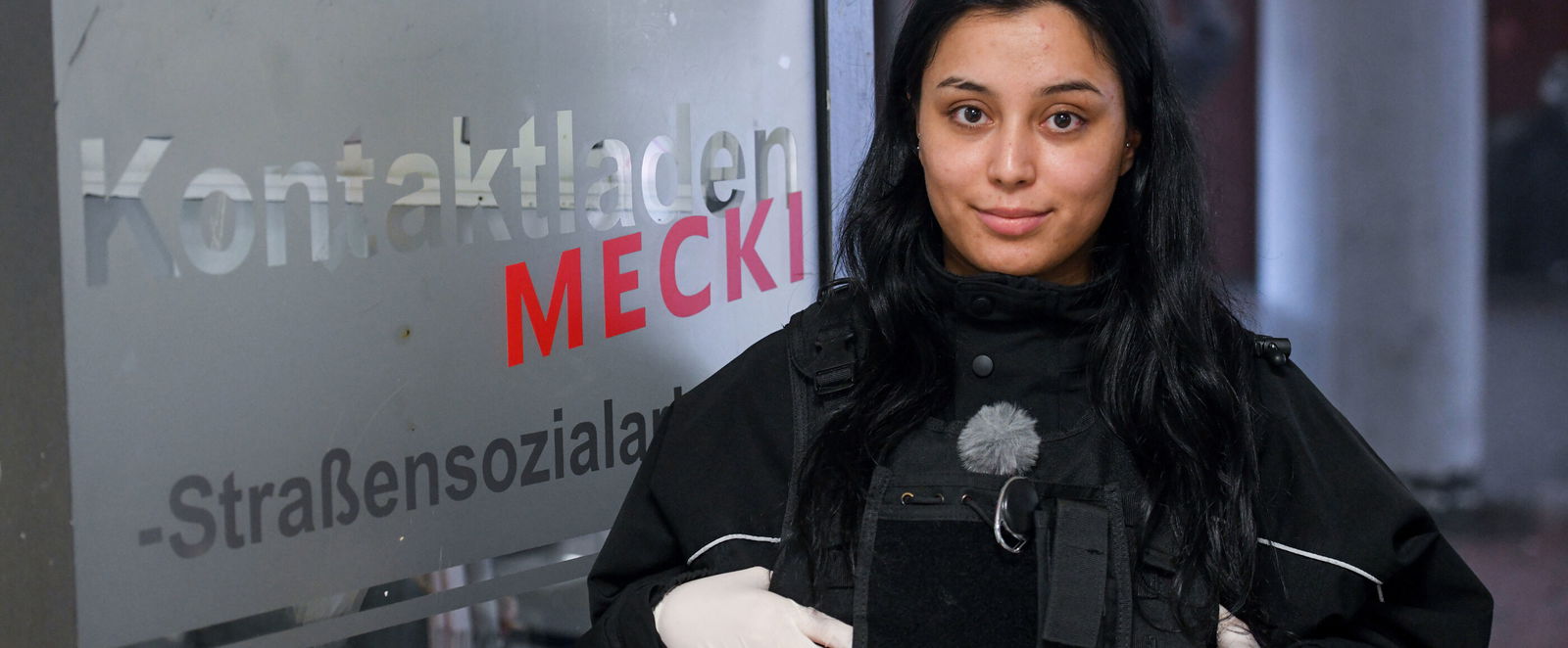 Eine junge Frau in Uniform lächelt verhalten in die Kamera.