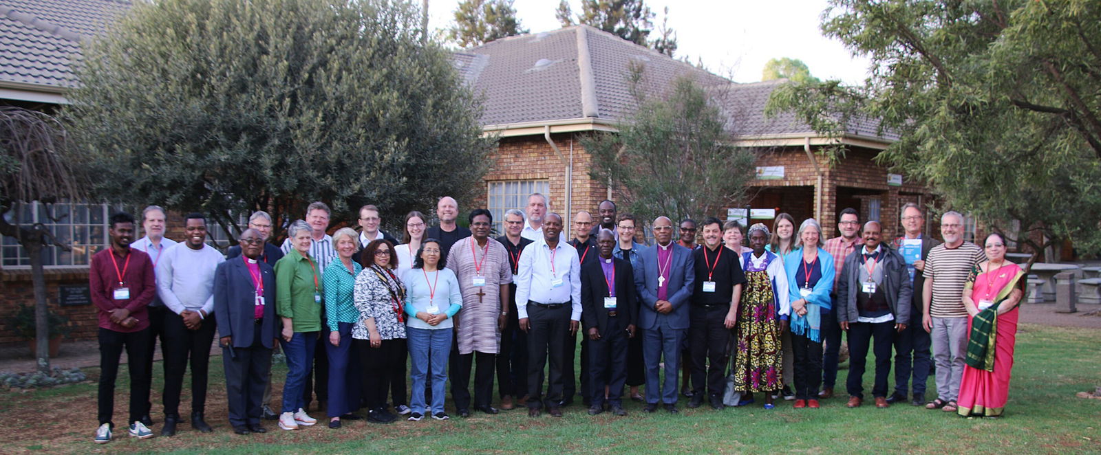 Ein Gruppenfoto im Freien mit mehreren Menschen unterschiedlicher Hautfarbe.