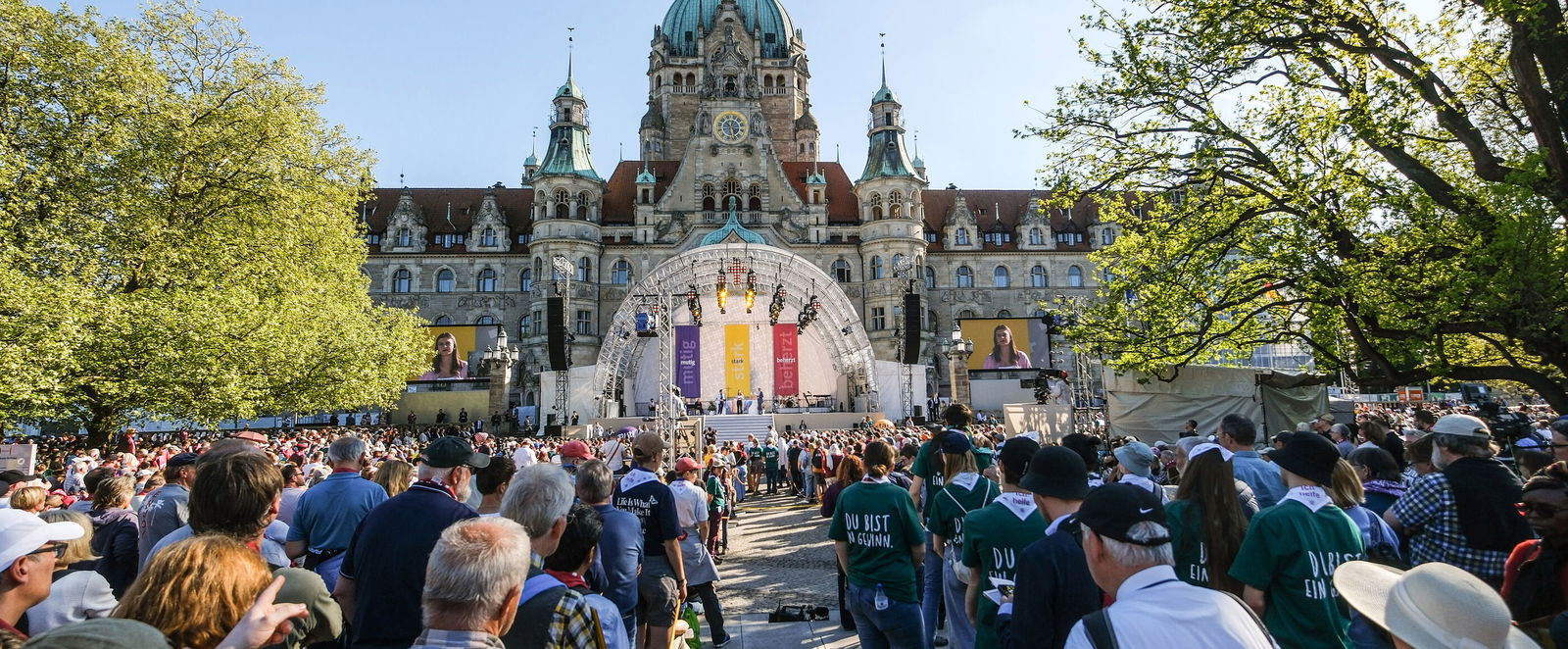 Blick aus einer Menschenmenge auf die Bühne vor dem Neuen Rathaus in Hannover.
