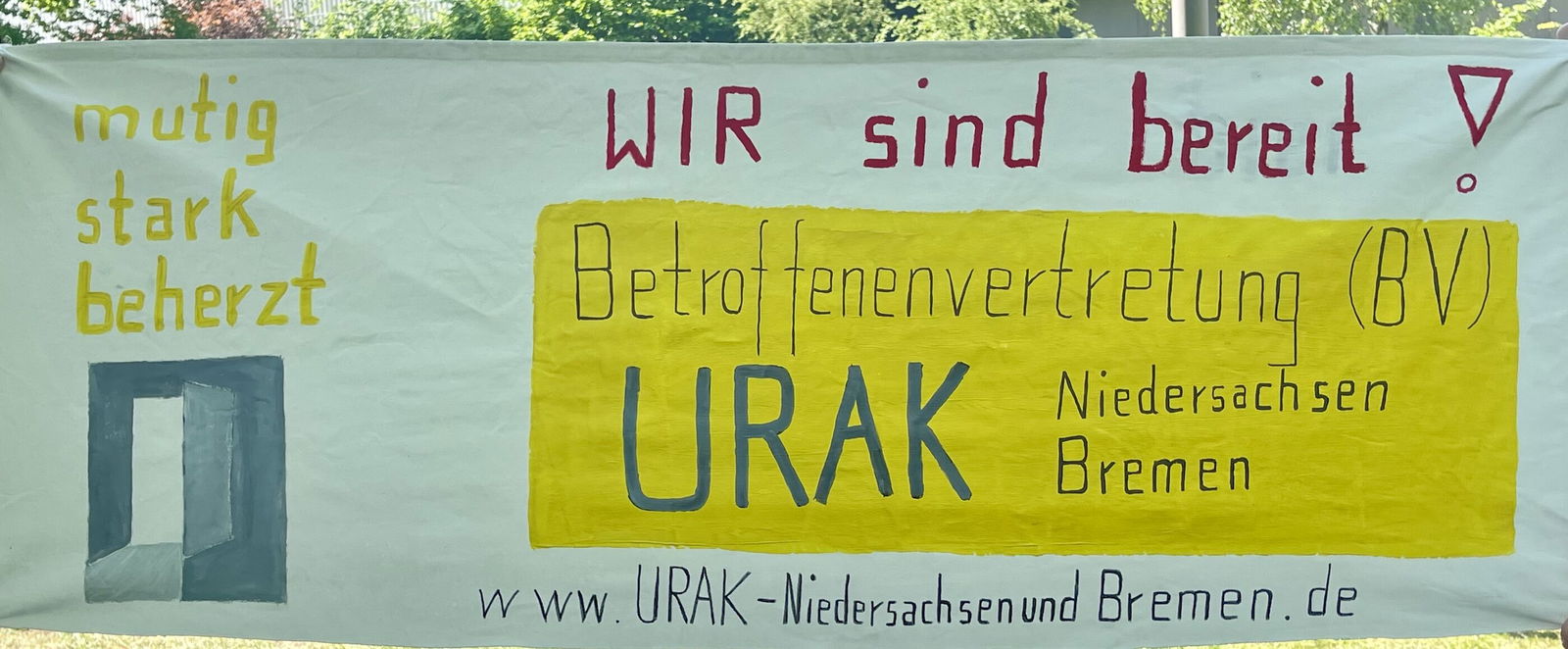 Ein Plakat an einem Zaun mit den Worten: URAK - wir sind bereit! Mutig, stark, beherzt