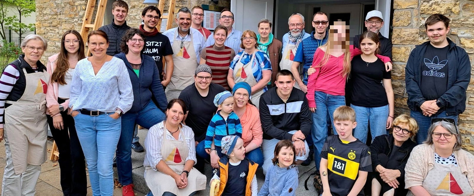 Eine altersmäßig bunt gemischte Gruppe vor einer Kirche