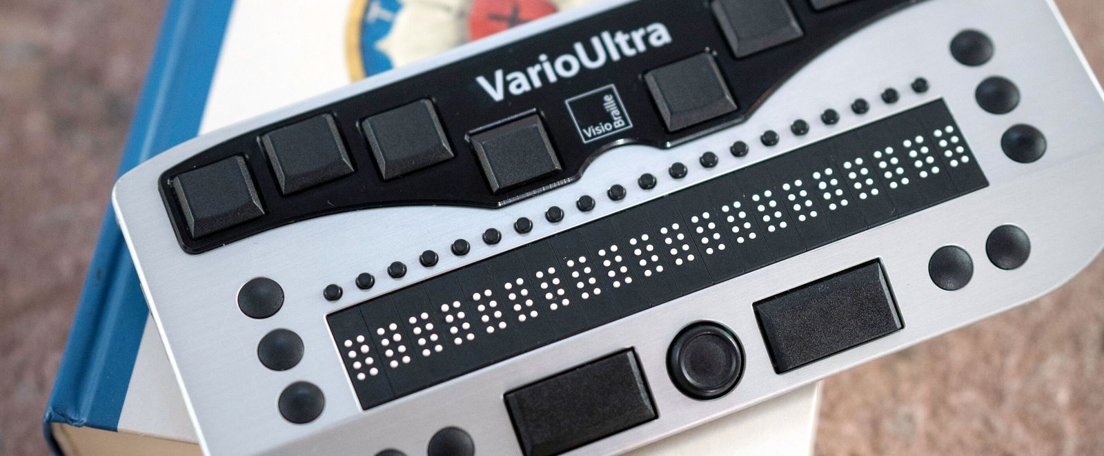 Ein kleines Gerät mit Braille-Punkten liegt auf einer Bibel.