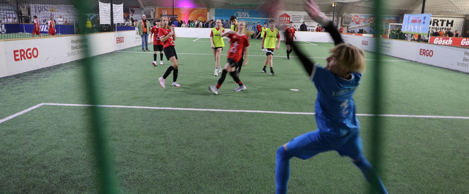 Szene bei einem Fußball-Spiel mit jungen Menschen: der Torhüter kann den Ball nicht mehr erreichen.