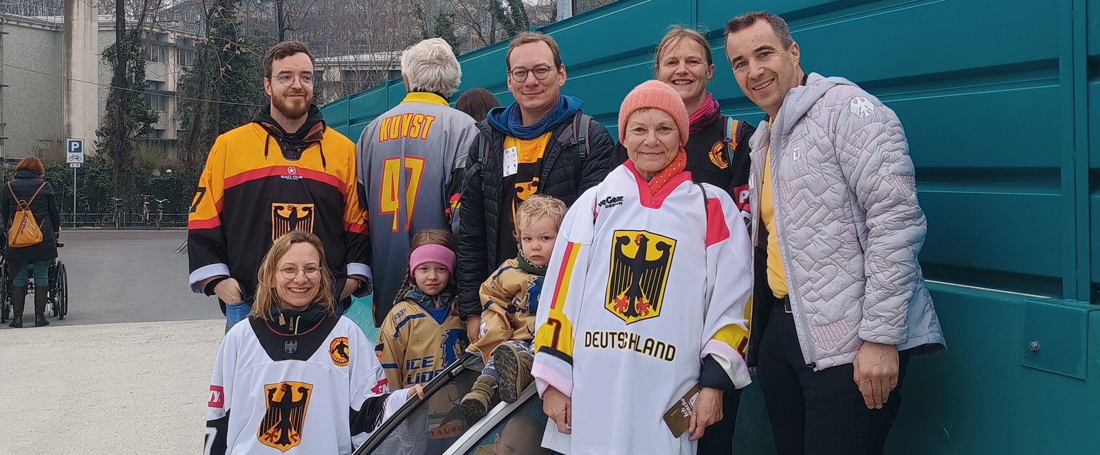 Mehrere Menschen in Deutschland-Trikots stehen für ein Gruppenbild zusammen.