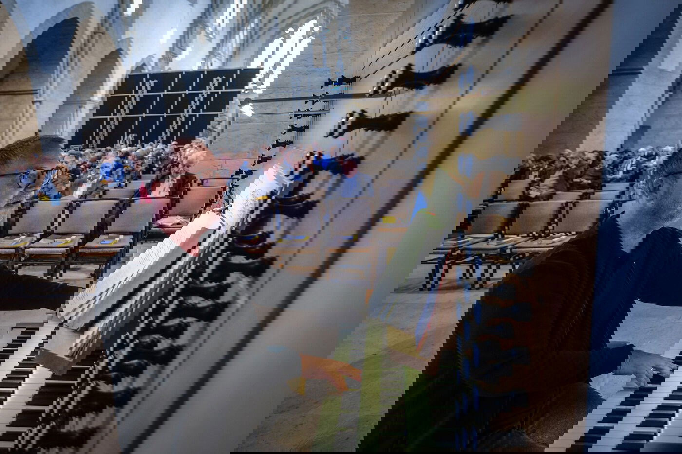 Organist beim Orgelspielen. Kirchensaal im Hintergrund. 
