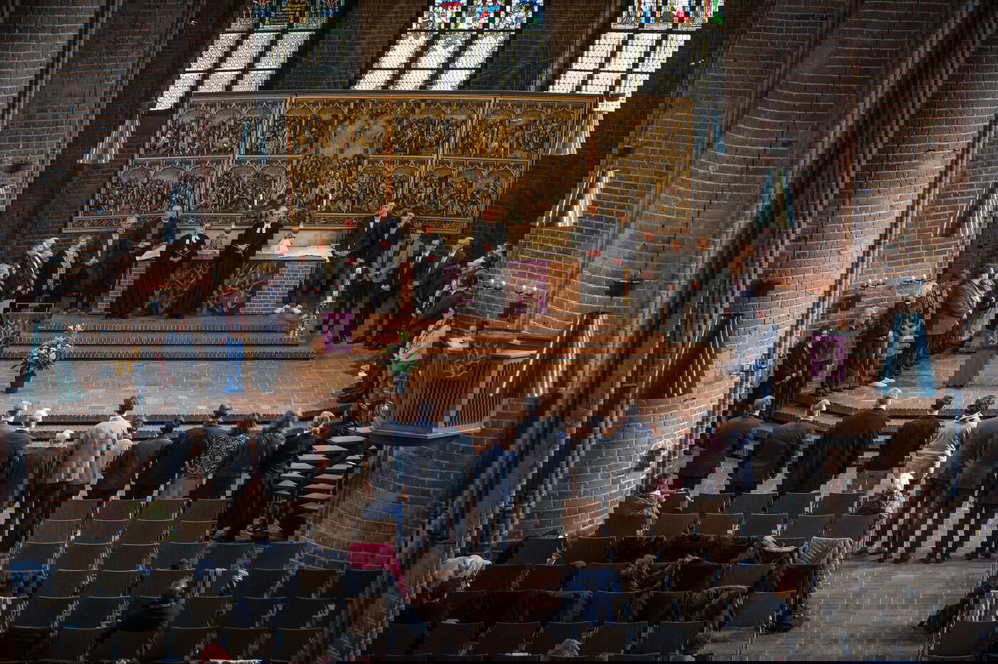 Viele Personen stehen rund um den Altar in einer Kirche