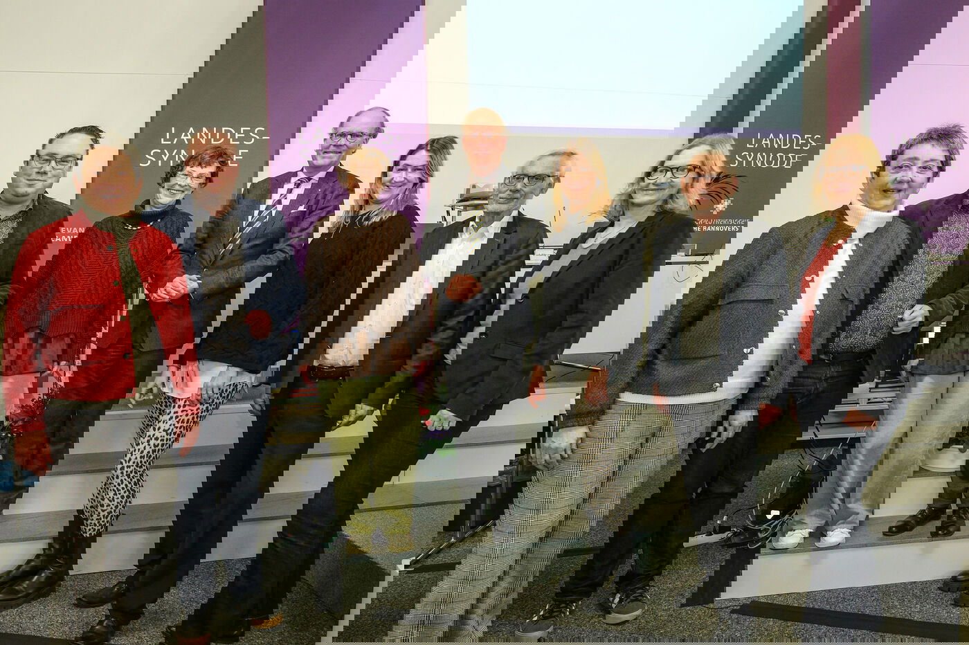 Mehrere Personen stehen zusammen und lächeln in die Kamera