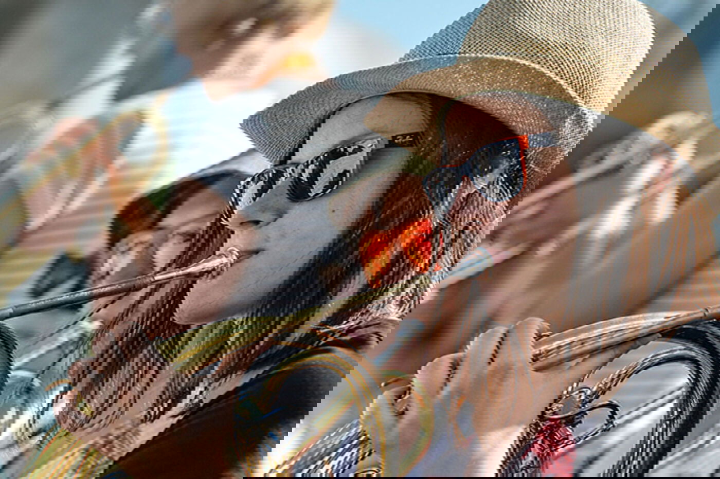 Eine junge Frau mit Sonnenbrille spielt Horn