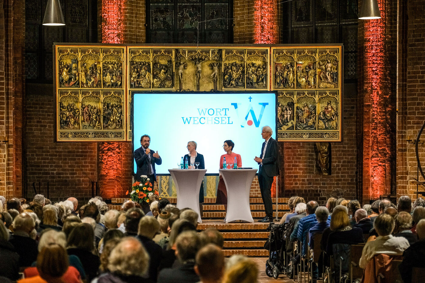Eine Gruppe diskutiert im Altarraum einer Kirche.